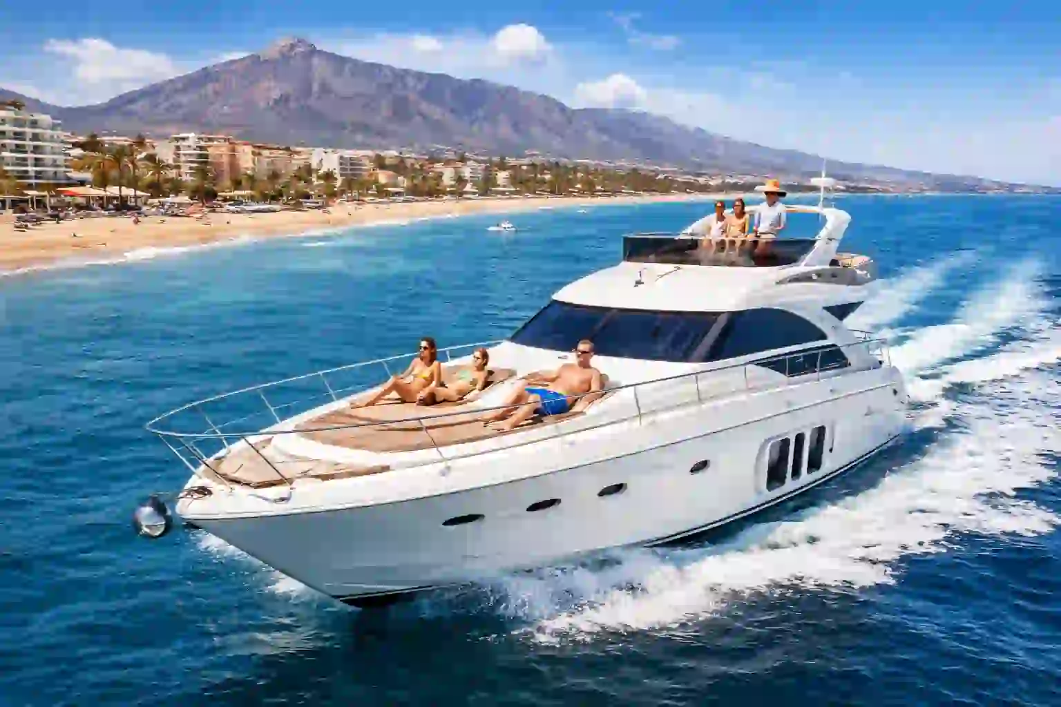 Marbella luxury coast tour: sailboat gliding past Puerto Banús marina with yachts and golden coastline.