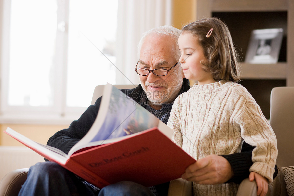 DELE B2 Übungen 1 Un abuelo con gafas y su nieta miran juntos un libro ilustrado
